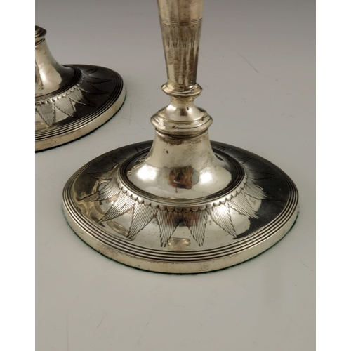 105 - A matched pair of Victorian and Edwardian silver candlesticks, Thomas Bradbury, London 1897 and 1903... 