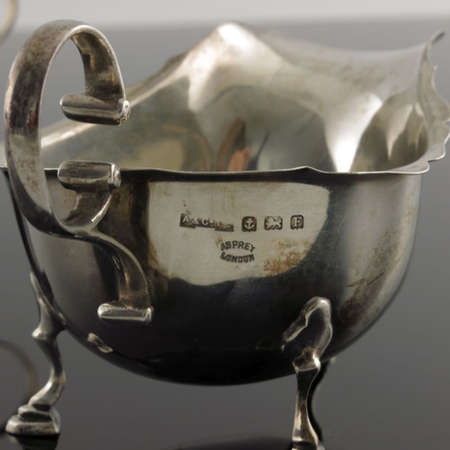 109 - A pair of George V silver sauce boats, Asprey and Co., Birmingham 1929/30, ogee rimmed helmet form w... 