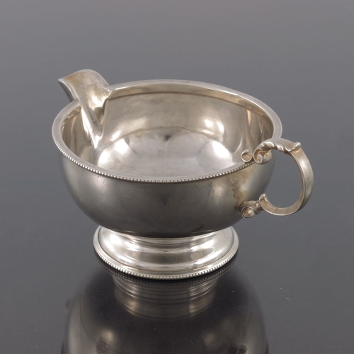 113 - A George V silver jug, Henry Clifford Davis, Birmingham 1924, hemispherical and footed form with bea... 