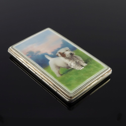 201 - A George V silver enamel cigarette case, the cover painted with a terrier dog in a grassy landscape,... 