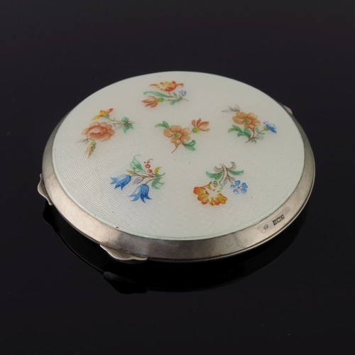 205 - Three silver circular powder compacts, in cream guilloche enamel and painted with various flowers, a... 