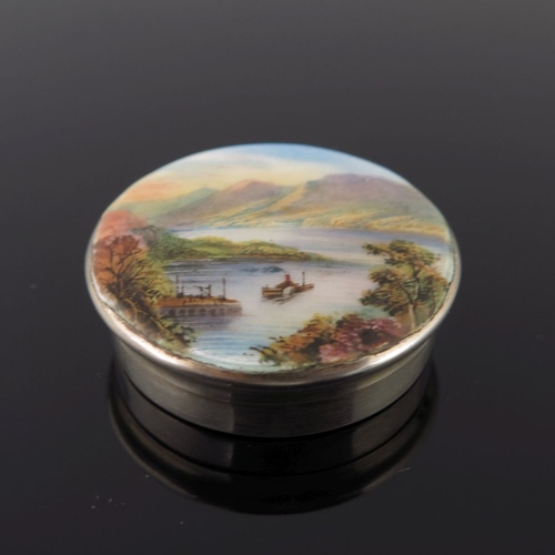 227 - A George V silver circular powder compact, the cover enamelled with a mountainous lake landscape, Bi... 