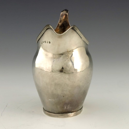 252 - A George III silver cream jug, Crispin Fuller overstruck Samuel Godbehere, London 1795, helmet form ... 