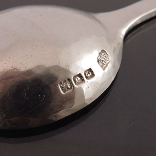 272 - Alwyn Carr, an Arts and Crafts silver spoon, London 1920, planished and cast with a thistle terminal... 