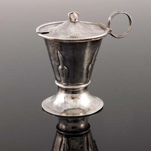 276 - A E Jones, an Arts and Crafts silver mustard pot, Birmingham 1912, flare footed conical form, applie... 