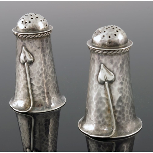 277 - A E Jones, a pair of Arts and Crafts silver pepper pots, Birmingham 1907, planished flared form, app... 