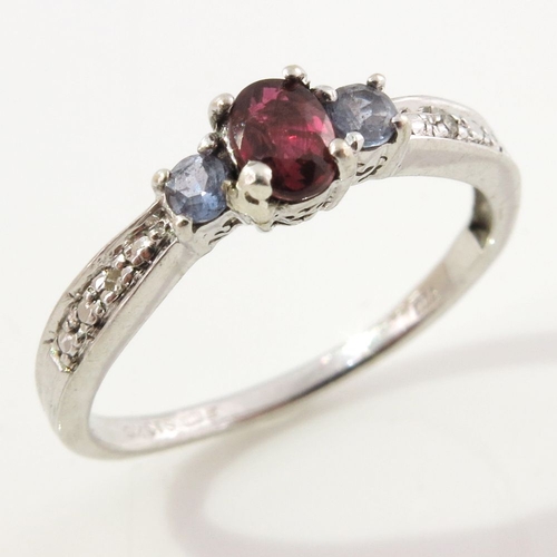 303 - A 9ct gold ruby and tanzanite three-stone dress ring, with single-cut diamond accent shoulders, hall... 