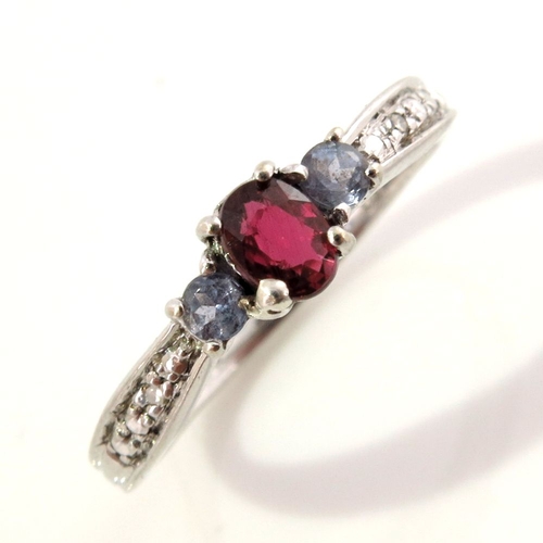 303 - A 9ct gold ruby and tanzanite three-stone dress ring, with single-cut diamond accent shoulders, hall... 