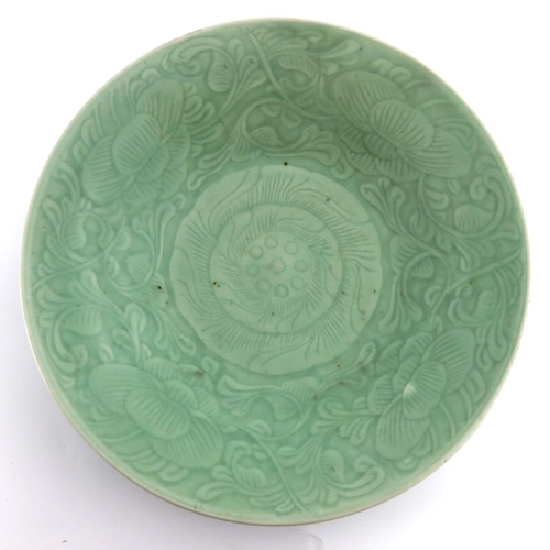 431 - A 18th century or later Chinese celadon glaze charger, underglaze central petal within a scrolling f... 