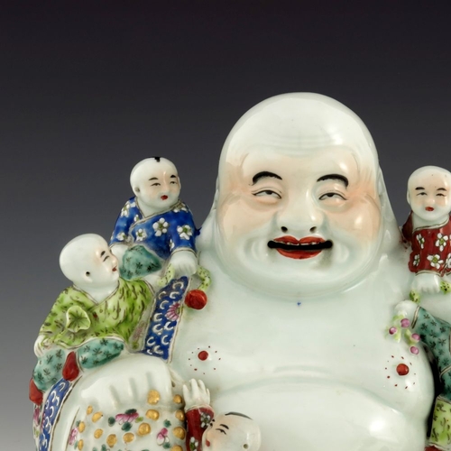 443 - A Chinese ceramic figure of Hotei, 20th century, seated smiling surrounded by five infants, polychro... 