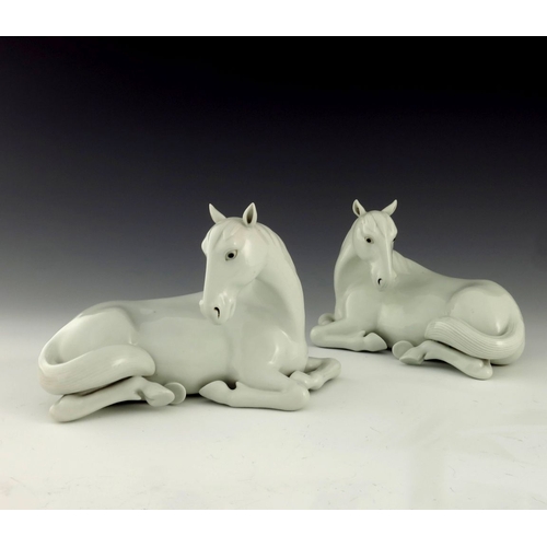 454 - A pair of Japanese Hirado porcelain models of recumbent horses, Meiji period, 1868-1912, white glaze... 