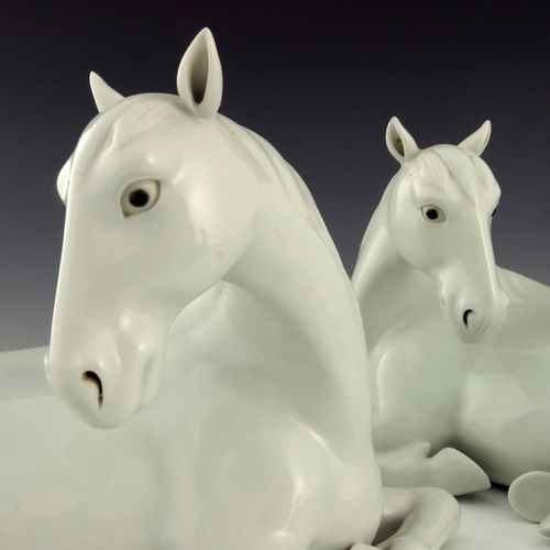 454 - A pair of Japanese Hirado porcelain models of recumbent horses, Meiji period, 1868-1912, white glaze... 