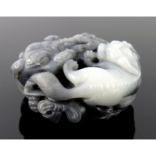 469 - A Chinese black and white jade pendant carving, in the form of large and small shi-shi, diameter 5cm