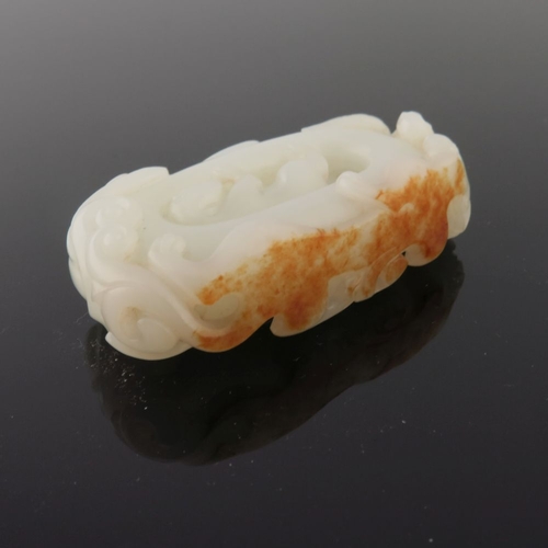 470 - A Chinese pale jade carving, reticulated with a dog, scroll border, width 6cm