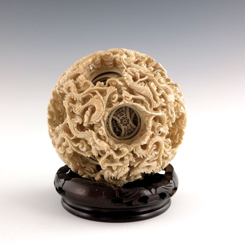 502 - λ A late 19th Century large Chinese ivory puzzle ball, the outer surface carved with reticulated dra... 