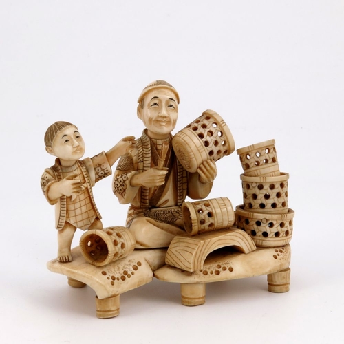 513 - λ A Japanese ivory okimono, Meiji period, 1868-1912, carved as a basket maker and his apprentice, si... 