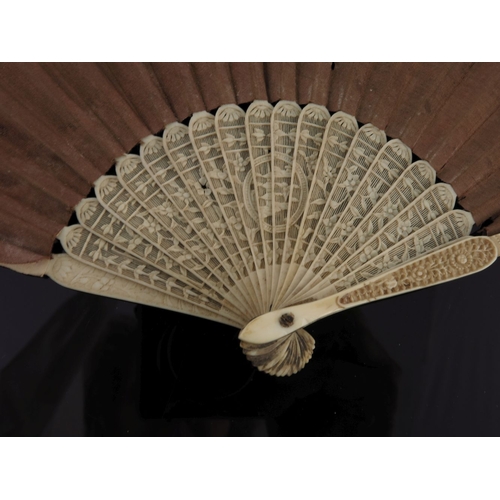 518 - λ A small Chinese export fan, early 19th century, with carved ivory sticks and plain silk leaf, the ... 