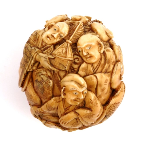 527 - λ A 19th century Japanese carved ivory ball, Meiji, modelled in relief with seated figures in conver... 