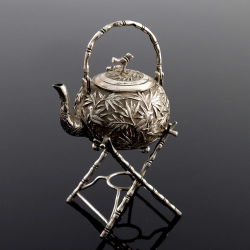 3 - A Chinese silver miniature model of a tea kettle on stand, early 20th Century, repousse decorated wi... 