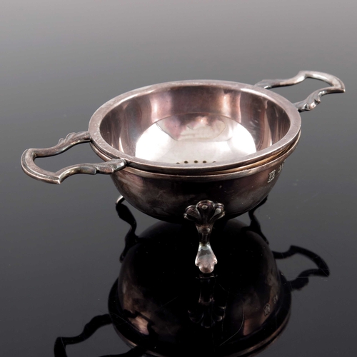 50 - An Elizabeth II silver tea strainer and stand, Barker Ellis Silver Co., Birmingham 1987, the rounded... 