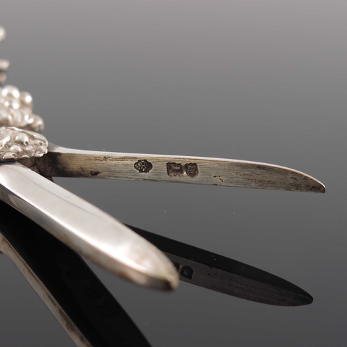 81 - A pair of Edwardian cast silver grape scissors, William Hutton and Sons, London 1901, the handles mo... 