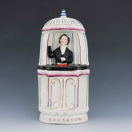 1096 - A Staffordshire figure of 'C.H. Spurgeon', circa 1860, modelled standing in a pulpit, his right arm ... 