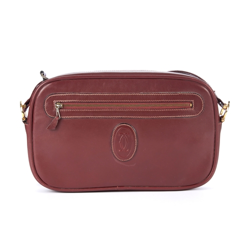 26 - Cartier, a vintage Bordeaux leather camera bag, crafted from smooth burgundy leather, featuring make... 