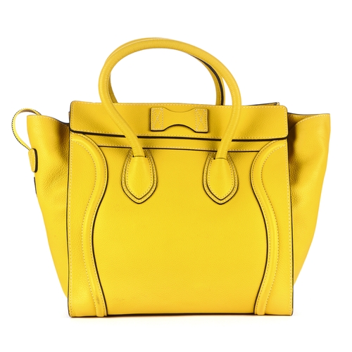 33 - Celine, a Mini Luggage tote, designed with a grained yellow leather exterior, featuring expandable l... 