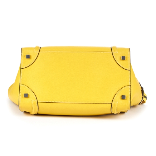 33 - Celine, a Mini Luggage tote, designed with a grained yellow leather exterior, featuring expandable l... 