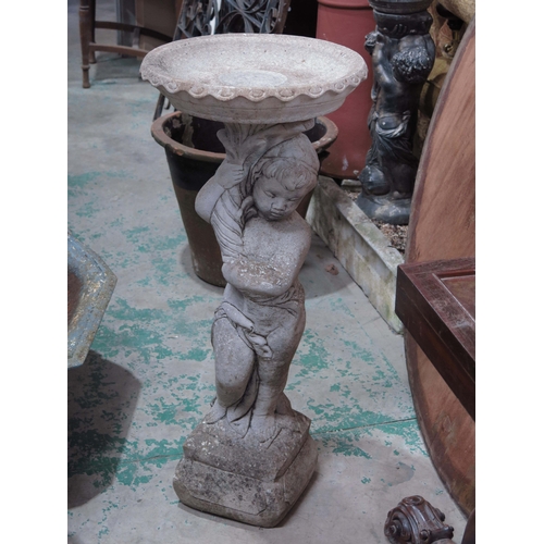 957 - A composite garden bird bath, supported by a cherub, 87cm high.