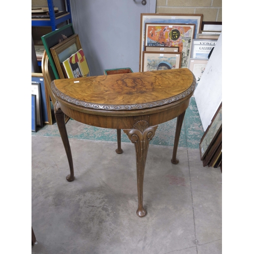 961 - A burr walnut veneered demi-lune games table, 73cm high