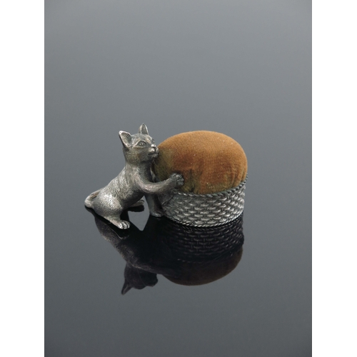 101 - A novelty white metal pin cushion, stamped mark for Mappin and Webb, modelled as a cat with a basket... 