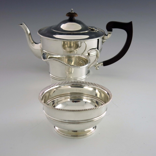 127 - A George V silver three piece tea set, Adie Brothers, Birmingham 1932/33, banded and rounded footed ... 