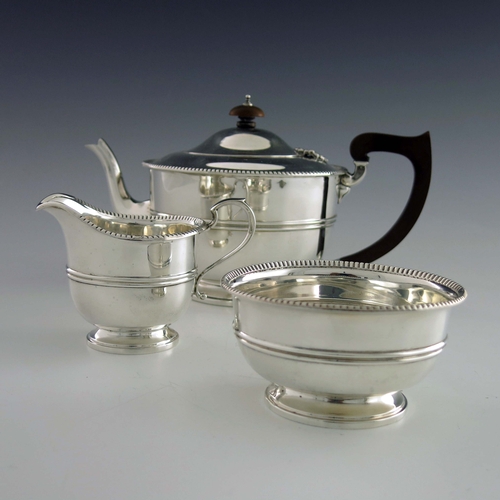 127 - A George V silver three piece tea set, Adie Brothers, Birmingham 1932/33, banded and rounded footed ... 