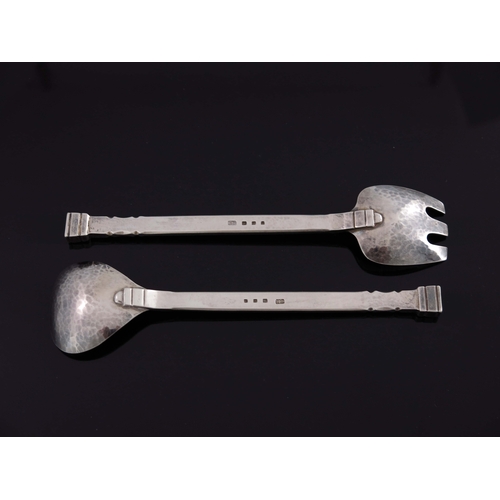 152 - Guild of Handicrafts, a pair of Arts and Craft silver salad servers, London 1939, planished and notc... 