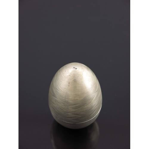 173 - A Modernist silver novelty surprise egg, Peter Nicholas and Co., London 1988, textured engine turned... 