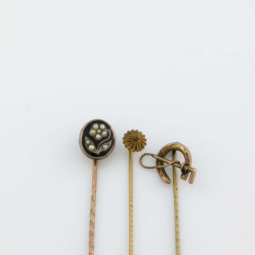 175 - Three yellow metal stick pins, including riding crop and horseshoe, enamel and split pearl floral mo... 