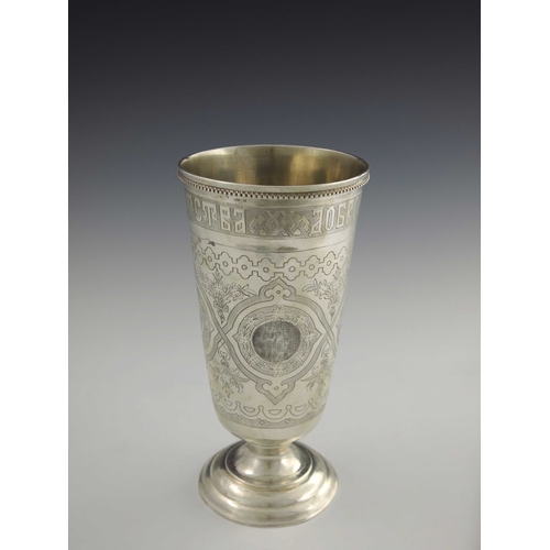 29 - A large Imperial Russian silver footed beaker, Moscow 1879, conical form, chased and engraved with w... 