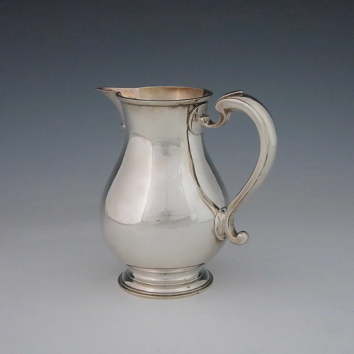 62 - A George V silver jug, John Hunt, London 1912, footed baluster form, with bracket spout and C S scro... 