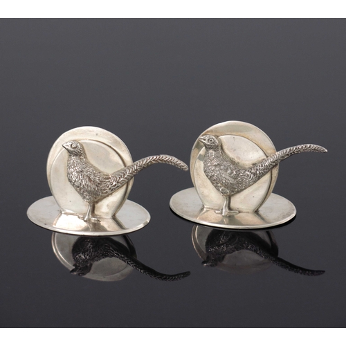 79 - A pair of George V silver menu holders, G Brace and Co., London 1932, modelled as pheasants, cast in... 