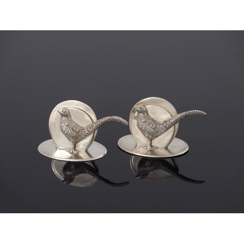 79 - A pair of George V silver menu holders, G Brace and Co., London 1932, modelled as pheasants, cast in... 