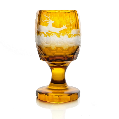 372 - A Bohemian etched and engraved glass goblet, facet cut and amber washed, decorated with a hunting sc... 