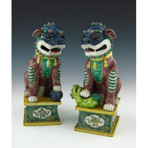 424 - A pair of Chinese ornamental models of shi shi beasts, each in coloured enamels, one with a ball, th... 