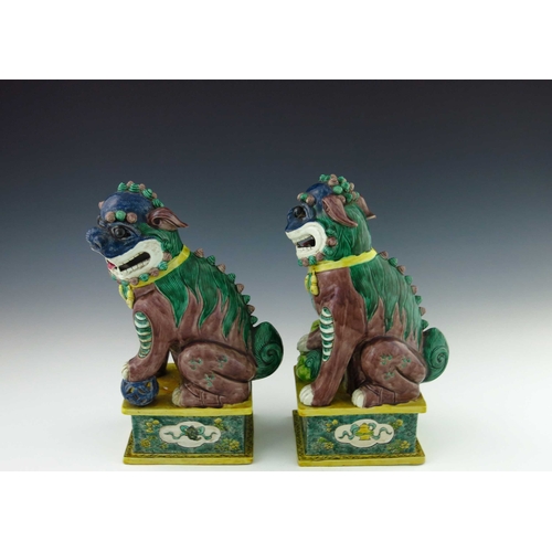 424 - A pair of Chinese ornamental models of shi shi beasts, each in coloured enamels, one with a ball, th... 