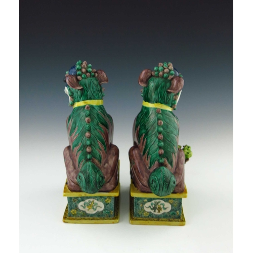 424 - A pair of Chinese ornamental models of shi shi beasts, each in coloured enamels, one with a ball, th... 