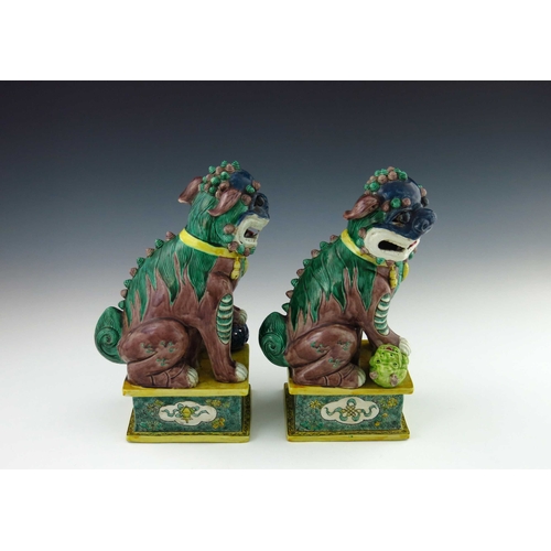 424 - A pair of Chinese ornamental models of shi shi beasts, each in coloured enamels, one with a ball, th... 