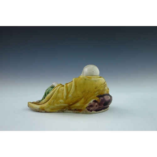 439 - An early 19th Century Chinese porcelain figure of a reclining smiling Buddha, green, yellow and purp... 