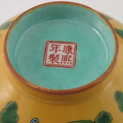 448 - A Chinese polychrome bowl, Kangxi mark, ogee form, yellow ground, enamelled with flowers and scrolli... 