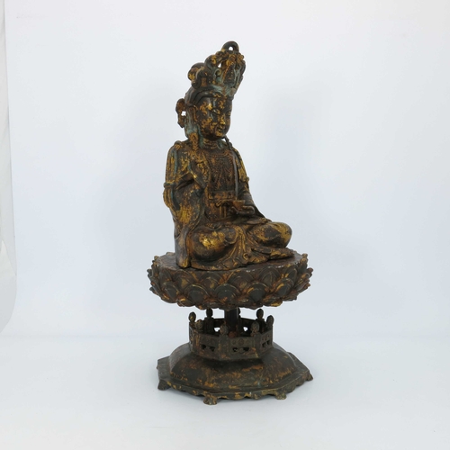 460 - A large Chinese gilt bronze figure of a deity, seated cross legged and wearing a headdress, mounted ... 