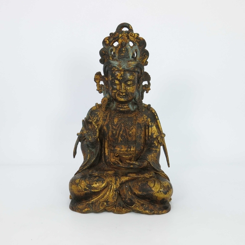 460 - A large Chinese gilt bronze figure of a deity, seated cross legged and wearing a headdress, mounted ... 